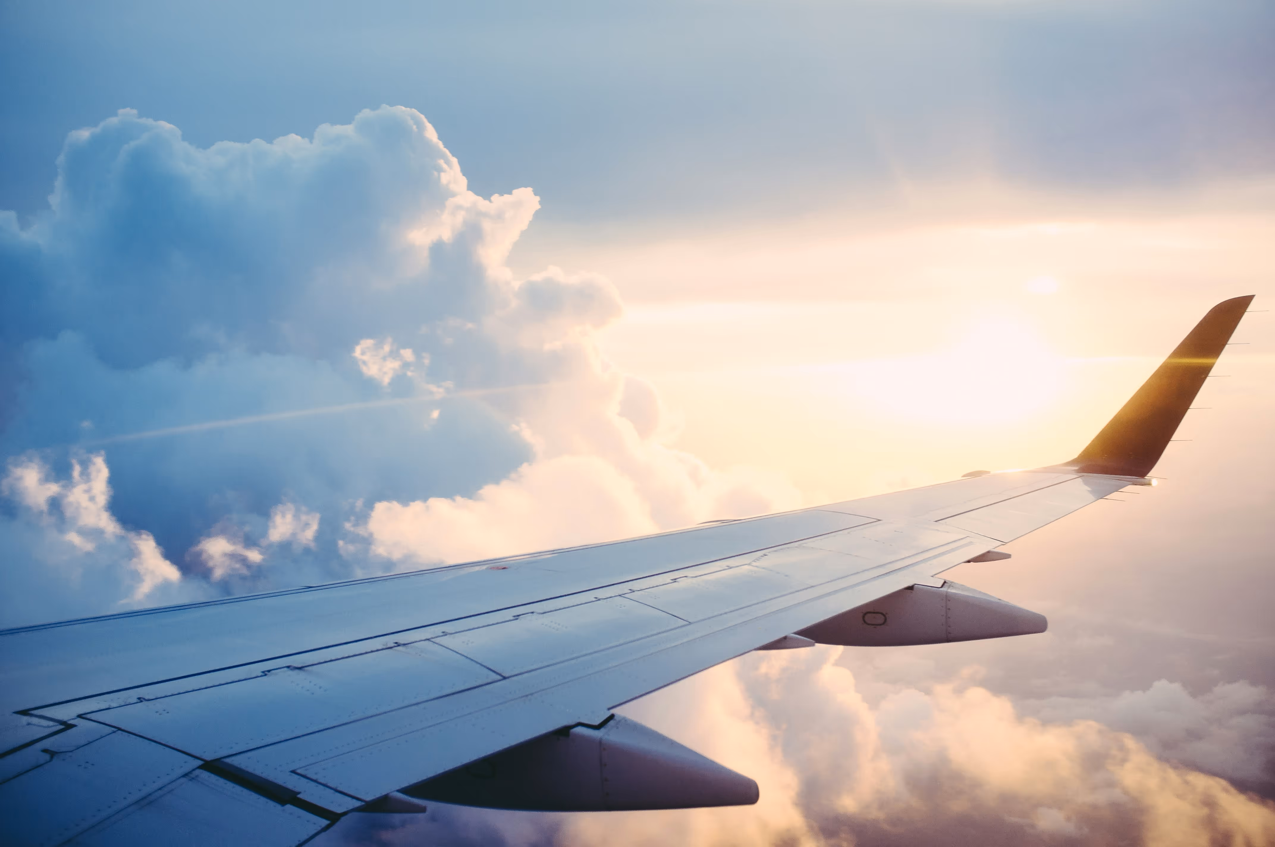 View from an airplane's right wing to the clouds below