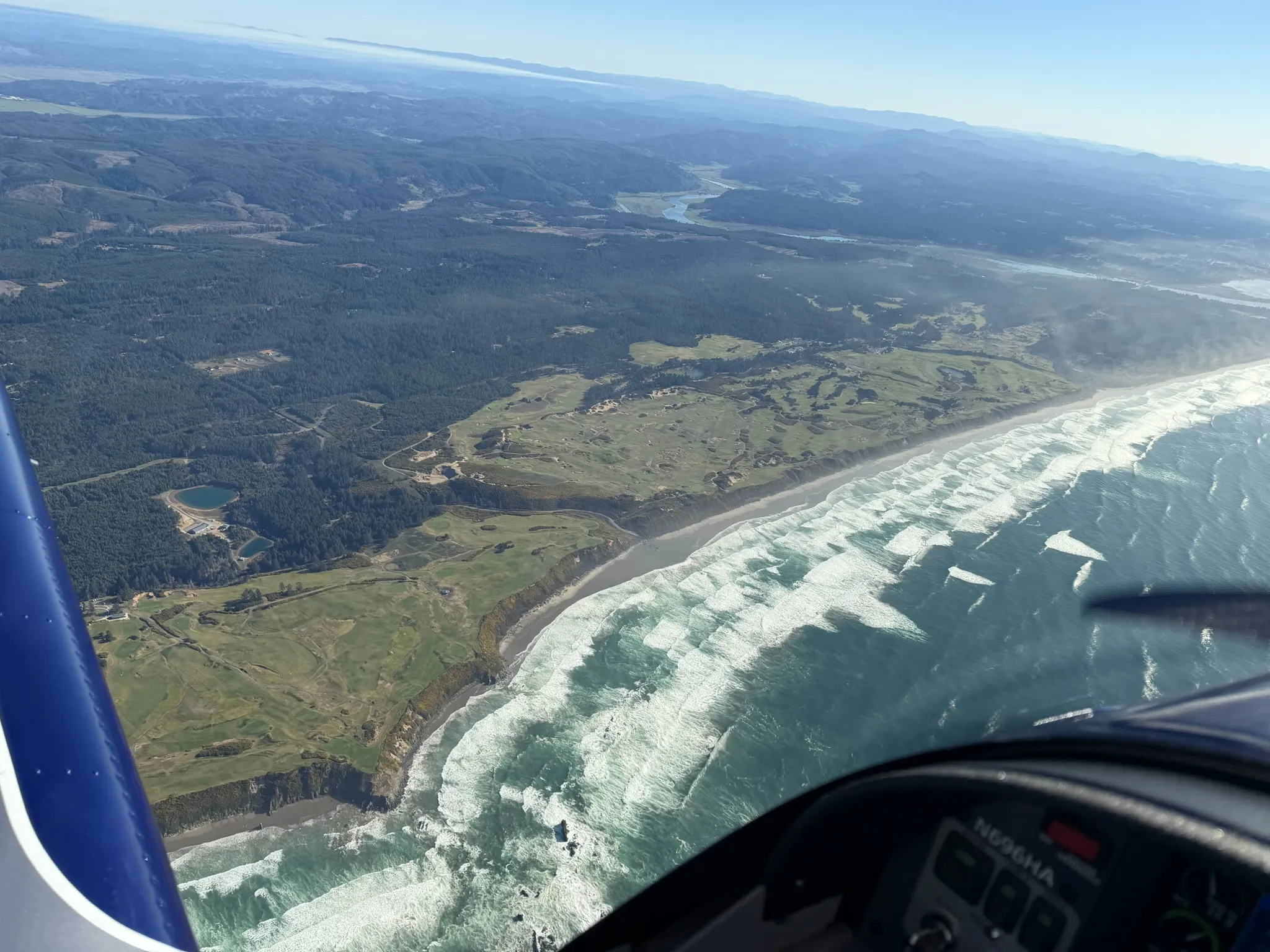 Three modern training aircraft flying in formation over the mountains