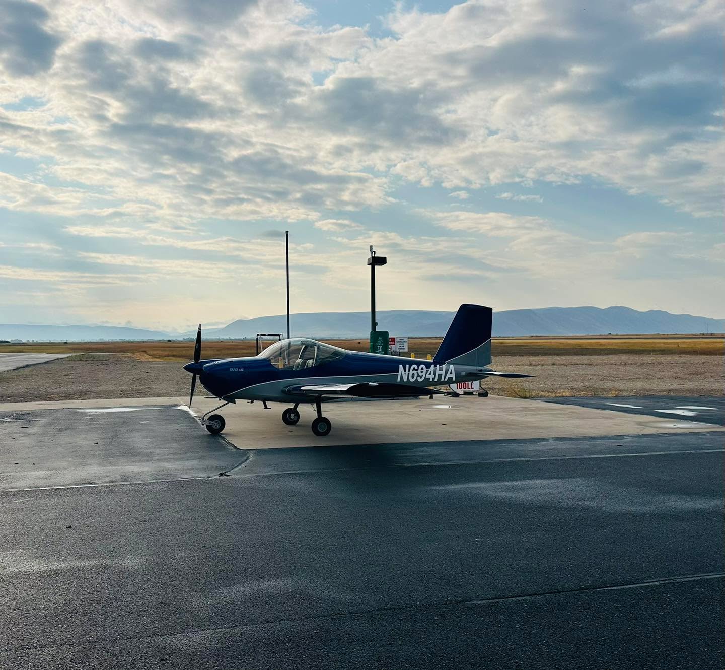 Hawkins Flight Academy RV-12 training aircraft parked beneath a cloud-filled sky