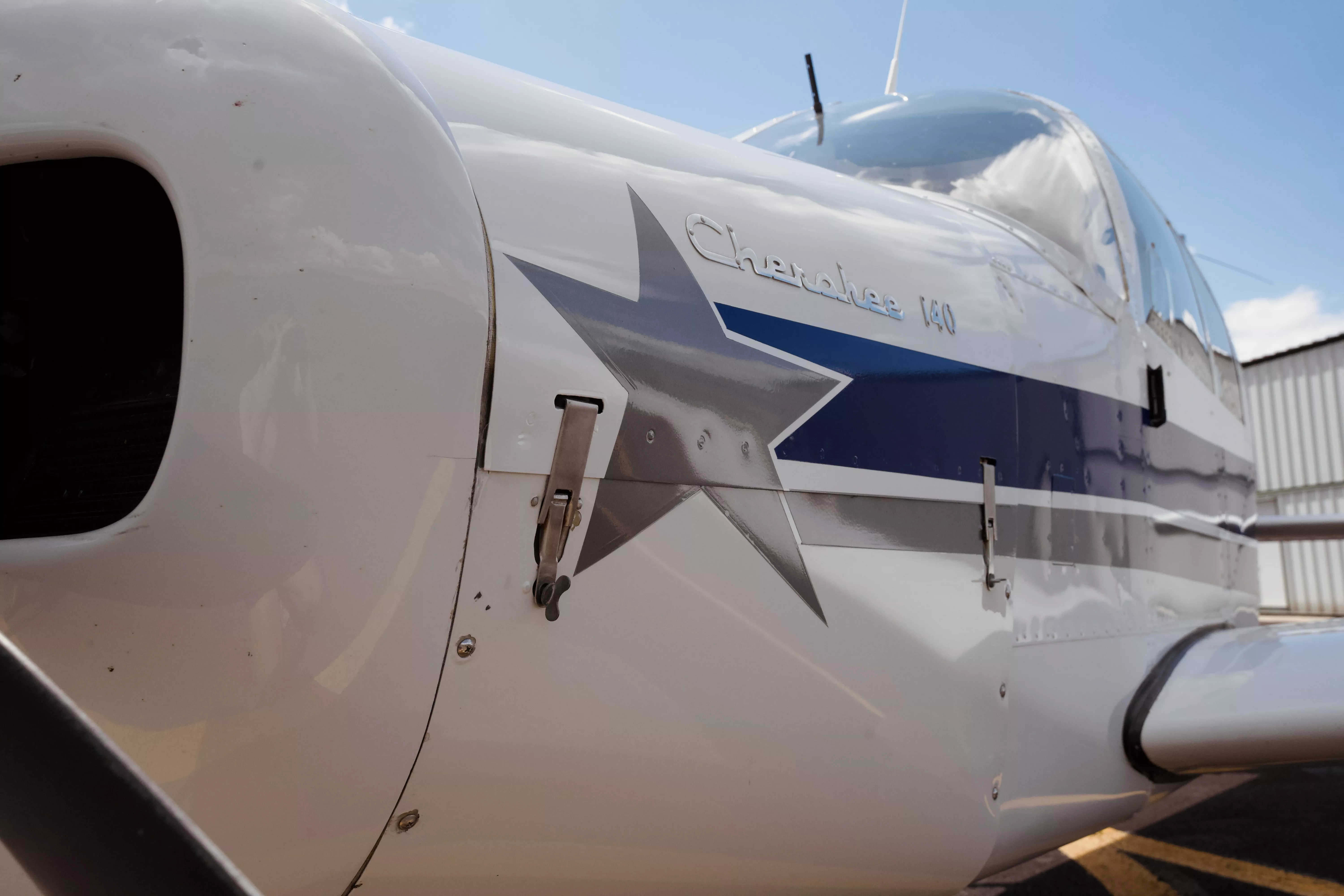 Piper Cherokee 140 exterior with the Cherokee 140 badge and Hawkins Flight Academy livery